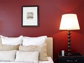 Red Wine Coloured Feature Wall with Cream Coloured Bedsheets